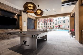 a ping pong table in the lobby of a building with a pool